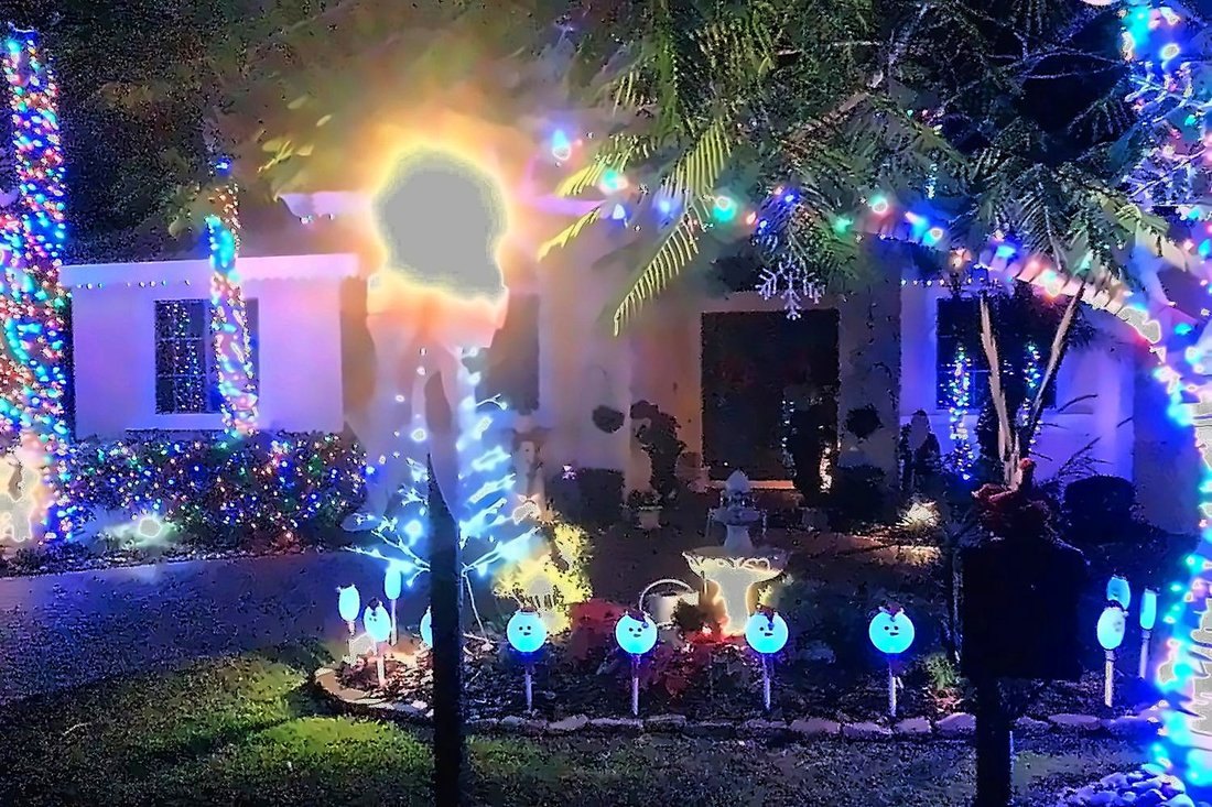 Home with colorful wrapped trunks, lit hedges and roofline, Largo holiday lighting