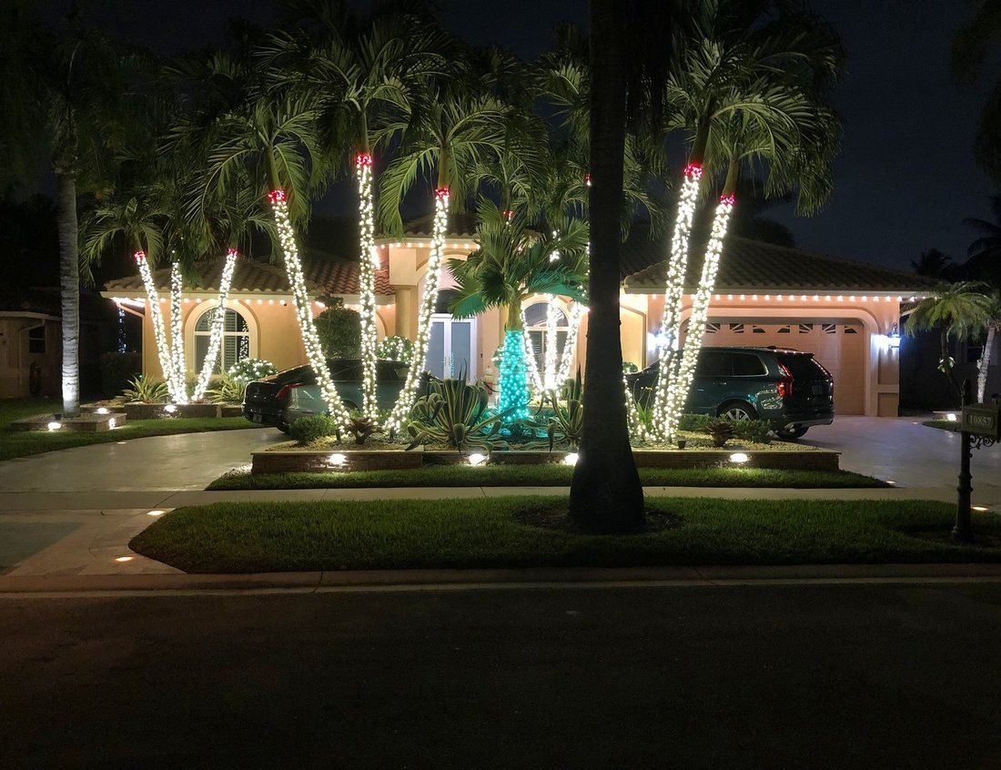 Quiet poolside roofline lit with warm icicle lighting at night, Palm Harbor holiday lighting