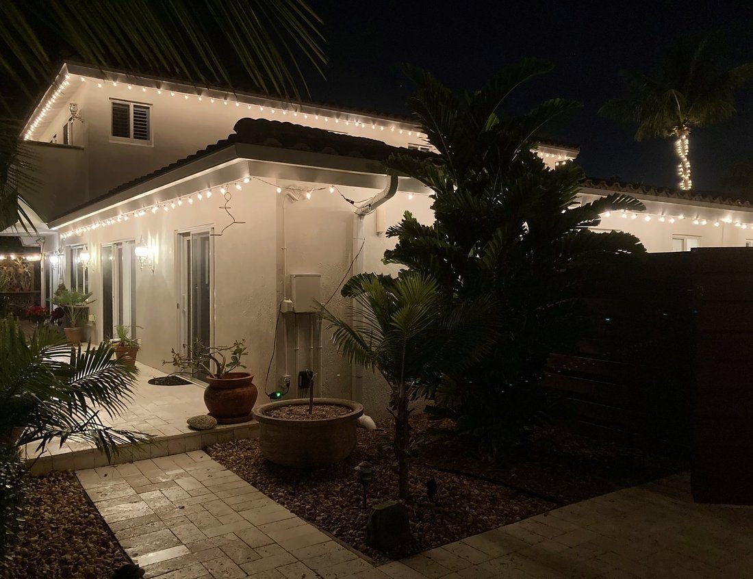 Two-story Mediterranean roofline lit at night on a wide lot, Snell Isle St. Petersburg holiday lighting
