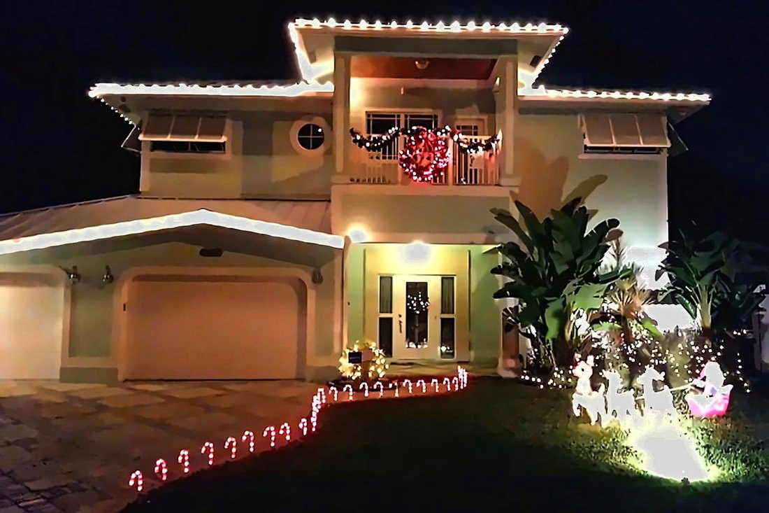 Two-story Mediterranean roofline outlined in warm lights, Tampa Christmas light installation