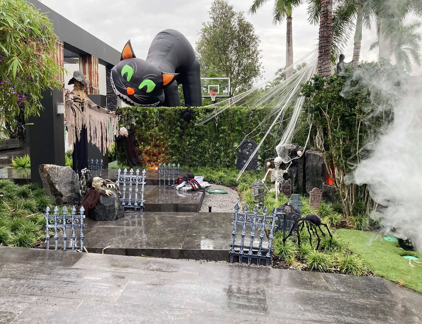 Giant inflatable black cat over a fogged Halloween graveyard scene